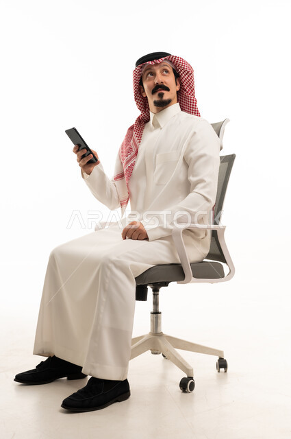Saudi Man on Office Chair Holding Smartphone
