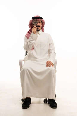 رجل سعودي مع عدسة مكبرة على خلفية بيضاء