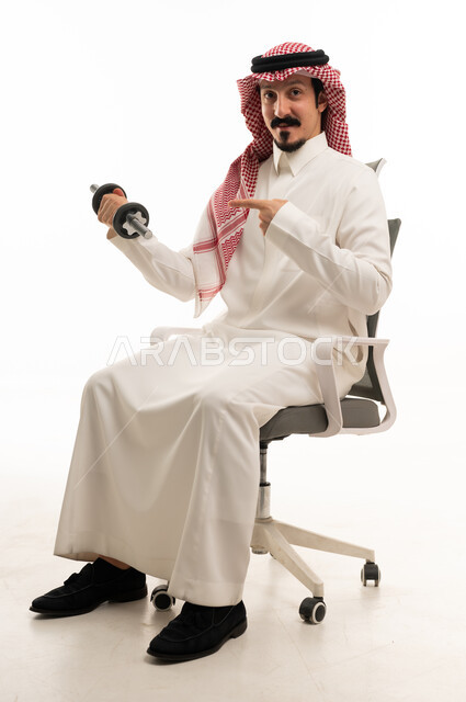 رجل سعودي يحمل وزن رياضي على كرسي مكتب خلفية بيضاء