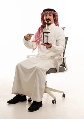 رجل أعمال سعودي مع ساعة رملية بخلفية بيضاء