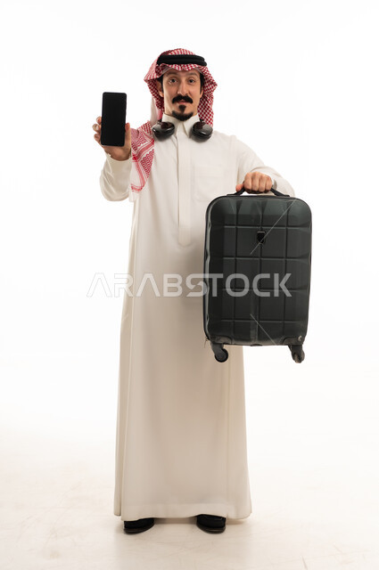 رجل سعودي مع حقيبة سفر وهاتف ذكي خلفية بيضاء