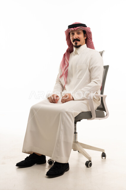 Saudi Man in Traditional Thobe Sitting on Office Chair