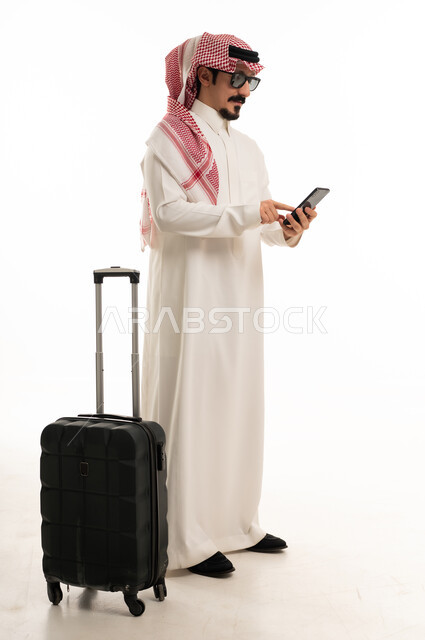 Saudi Man with Suitcase Using Smartphone on White