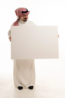 رجل سعودي يحمل لوحة بيضاء فارغة في استوديو