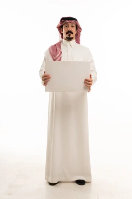 رجل سعودي يحمل لوحة بيضاء فارغة في الاستوديو