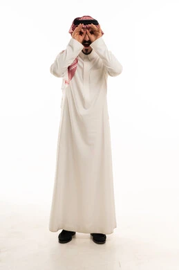 رجل سعودي بالثوب التقليدي يؤدي حركة المنظار