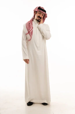 رجل سعودي يمسك فكه متألماً أمام خلفية بيضاء