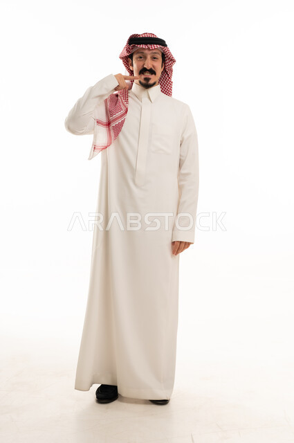 رجل سعودي بالثوب التقليدي يشير إلى فمه