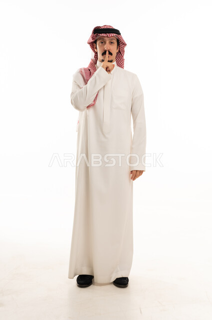 Saudi Man in Traditional Thobe Making Silence Gesture
