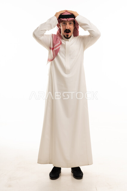 رجل سعودي بزي تقليدي مصدوم أمام خلفية بيضاء