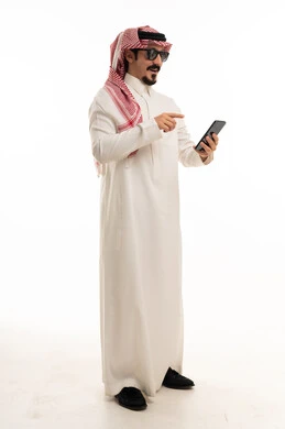 رجل سعودي بالزي التقليدي يحمل هاتف ذكي