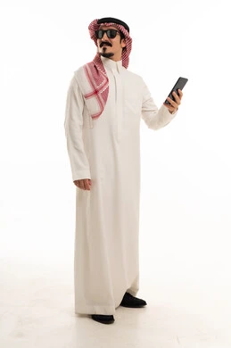 رجل سعودي بالثوب التقليدي يمسك هاتف ذكي