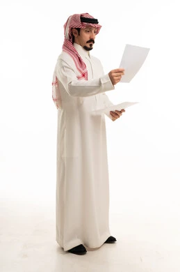 رجل سعودي بالثوب يقرأ مستندات على خلفية بيضاء