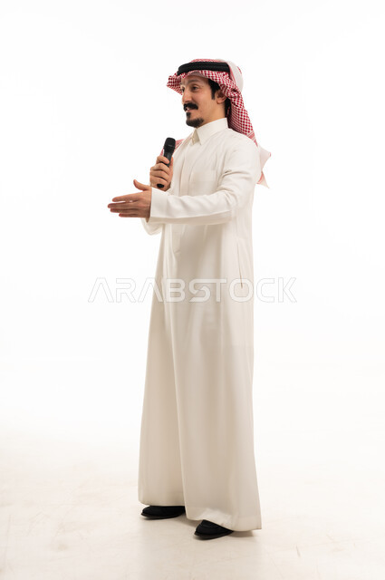 رجل سعودي يتحدث في الميكروفون في استوديو أبيض