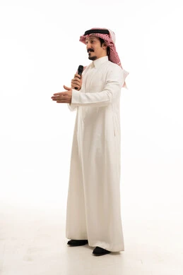 رجل سعودي يتحدث في الميكروفون في استوديو أبيض