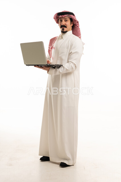 رجل أعمال سعودي بالزي التقليدي مع جهاز محمول خلفية بيضاء