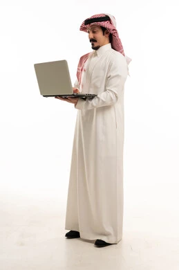 رجل سعودي بالزي التقليدي يستخدم الحاسوب المحمول خلفية بيضاء