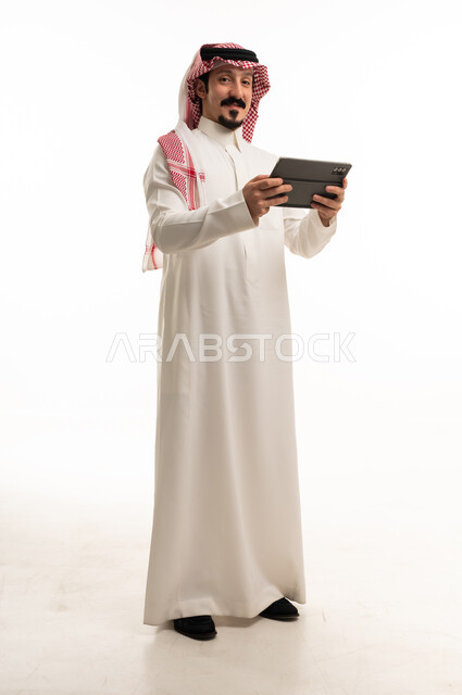 رجل سعودي مع جهاز لوحي بخلفية بيضاء