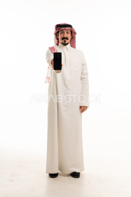 رجل سعودي يحمل هاتف ذكي على خلفية بيضاء
