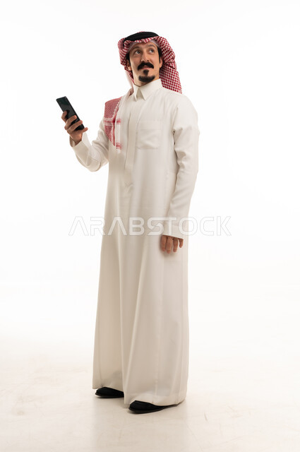 Saudi Man in Traditional Thobe Using Smartphone
