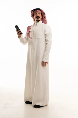 رجل سعودي بالثوب التقليدي يستخدم الهاتف الذكي