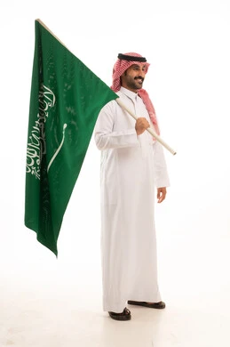 Saudi Man in Traditional Thobe Holding National Flag