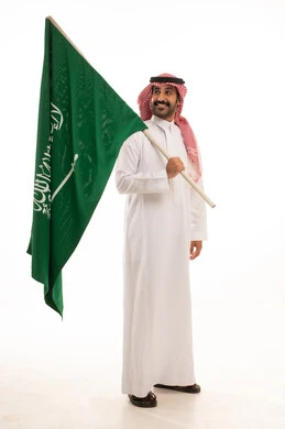Saudi Man in Thobe Holding National Flag on White