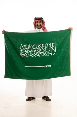 Saudi Man in Traditional Thobe Holding Saudi Arabia Flag
