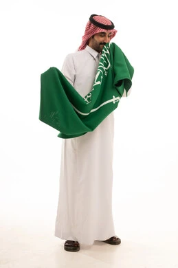 Saudi Man in Traditional Thobe Holding National Flag
