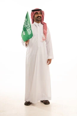 رجل سعودي يحمل العلم الوطني السعودي في اليوم الوطني