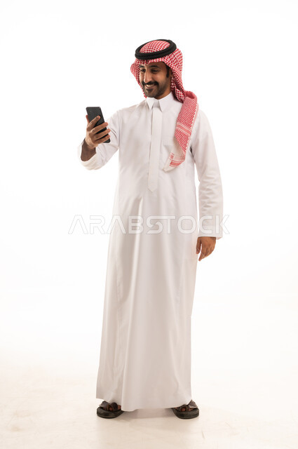 Saudi Man in Thobe Using Smartphone on White Background