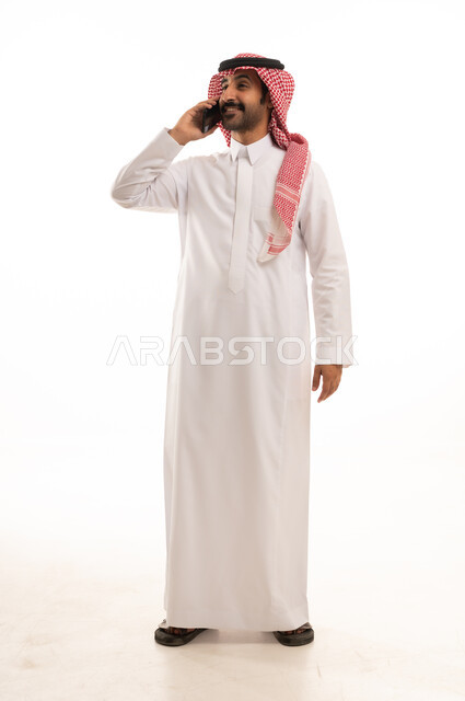 رجل سعودي بالثوب والشماغ يتحدث بالهاتف