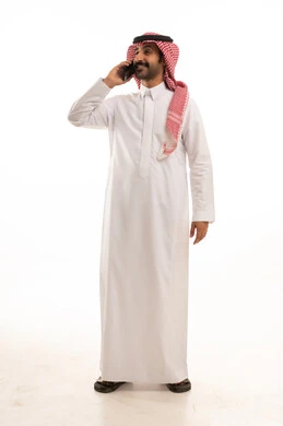 رجل سعودي بالثوب والشماغ يتحدث بالهاتف
