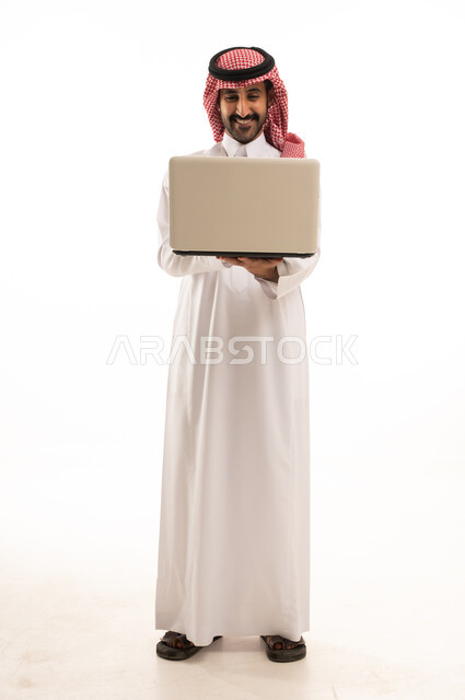 رجل سعودي بالثوب والشماغ يمسك لابتوب خلفية بيضاء