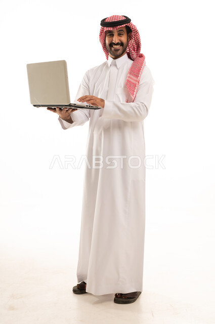 Saudi Man in Traditional Thobe Holding Laptop Studio Shot
