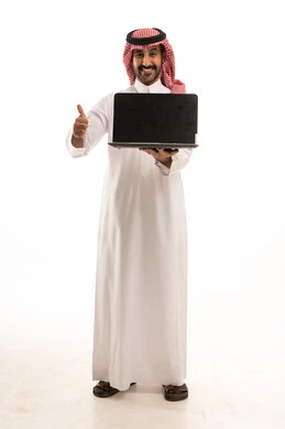 رجل سعودي بالثوب يمسك لابتوب مع إشارة الإعجاب