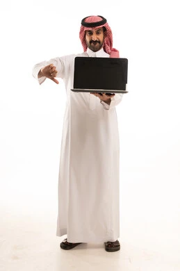 رجل سعودي يحمل لابتوب مع إشارة عدم إعجاب