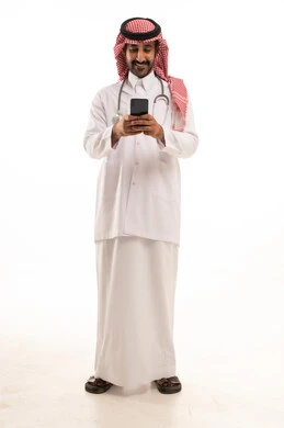 طبيب سعودي بالزي التقليدي يستخدم الهاتف الذكي
