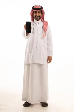 طبيب سعودي يمسك هاتفاً ذكياً بخلفية بيضاء