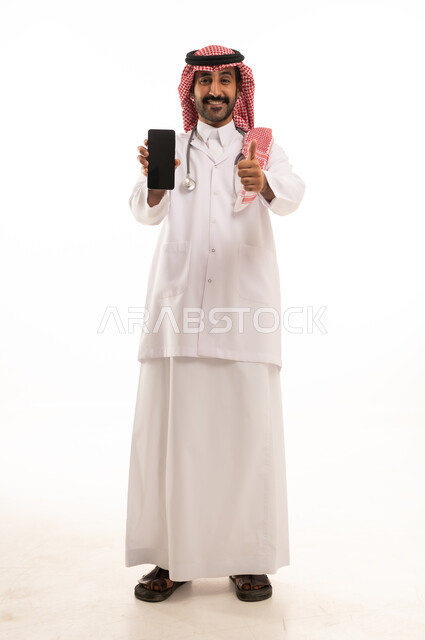 طبيب سعودي بالزي التقليدي يحمل هاتف ذكي