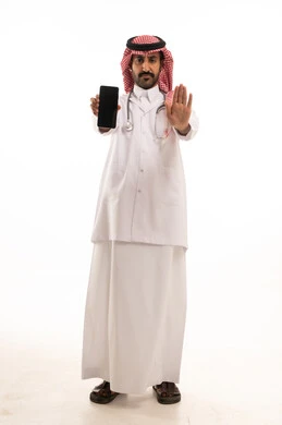 طبيب سعودي يحمل هاتف ويشير بعلامة التوقف