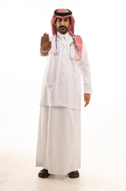 طبيب سعودي بالثوب والشماغ يشير بعلامة التوقف