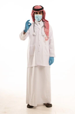 طبيب سعودي بالزي الرسمي يرتدي كمامة طبية