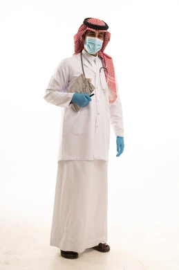 طبيب سعودي بالزي التقليدي والبالطو الأبيض الطبي