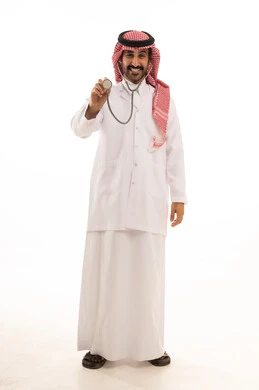 طبيب سعودي بالزي التقليدي يمسك سماعة طبية بخلفية بيضاء