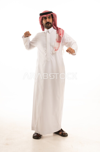 التدرب على الحركات القتالية، زيادة قدرة العضلات على التحمل، بورتريه لرجل عربي خليجي سعودي يرتدي الثوب الابيض والشماغ  يتعلم فنون الملاكمة، المحافظة على اللياقة البدنية، تعزيز صحة العظام والمفاصل، صورة الجسم بالطول الكامل، خلفية بيضاء.