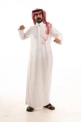 التدرب على الحركات القتالية، زيادة قدرة العضلات على التحمل، بورتريه لرجل عربي خليجي سعودي يرتدي الثوب الابيض والشماغ  يتعلم فنون الملاكمة، المحافظة على اللياقة البدنية، تعزيز صحة العظام والمفاصل، صورة الجسم بالطول الكامل، خلفية بيضاء.