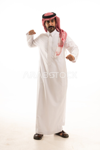 التدرب على الحركات القتالية، زيادة قدرة العضلات على التحمل، بورتريه لرجل عربي خليجي سعودي يرتدي الثوب الابيض والشماغ  يتعلم فنون الملاكمة، المحافظة على اللياقة البدنية، تعزيز صحة العظام والمفاصل، صورة الجسم بالطول الكامل، خلفية بيضاء.