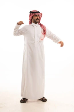 التدرب على الحركات القتالية، زيادة قدرة العضلات على التحمل، بورتريه لرجل عربي خليجي سعودي يرتدي الثوب الابيض والشماغ  يتعلم فنون الملاكمة، المحافظة على اللياقة البدنية، تعزيز صحة العظام والمفاصل، صورة الجسم بالطول الكامل، خلفية بيضاء.