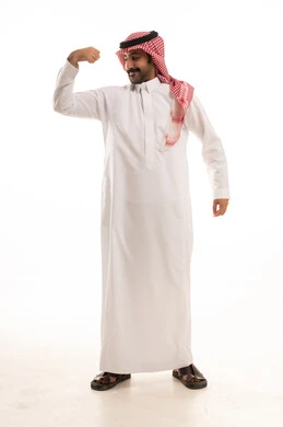 رياضة كمال الأجسام، اللياقة البدنية للاعبين، بناء جسم رياضي، بورتريه لرجل عربي خليجي سعودي يرتدي الزي التقليدي والشماغ يرفع عضلات يدية ، صورة لكامل الجسم، خلفية بيضاء